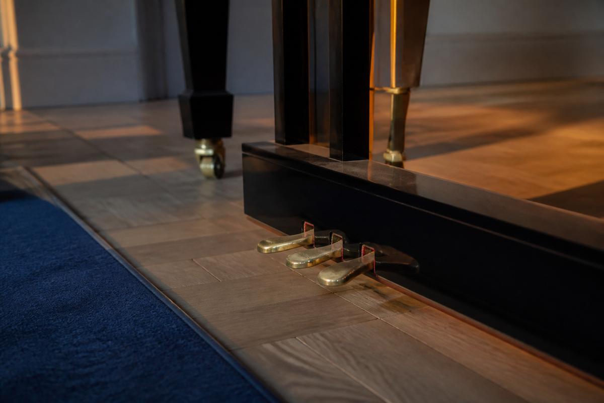 Brass piano pedals on oak flooring