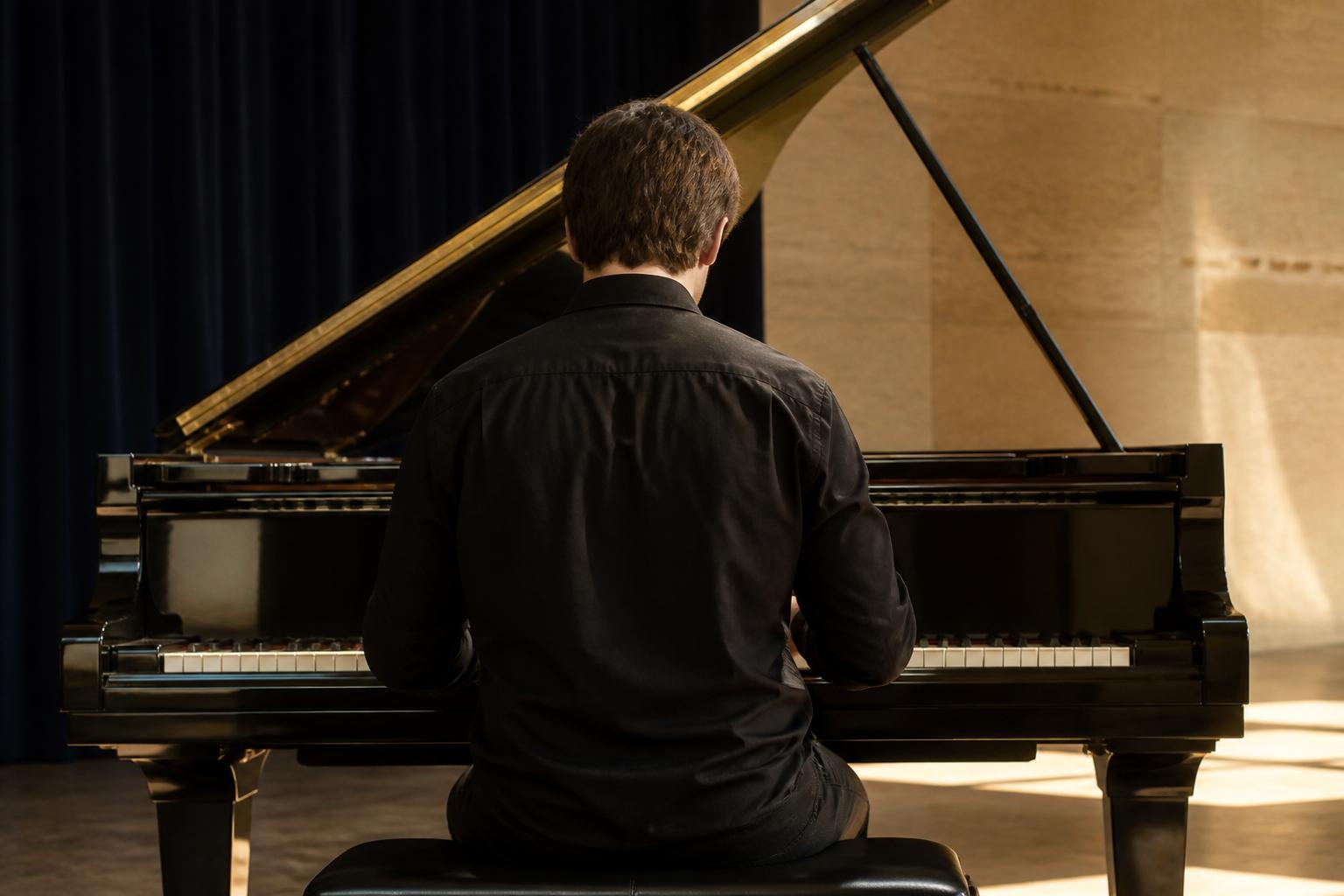 Adult pianist at a grand piano in a bright studio